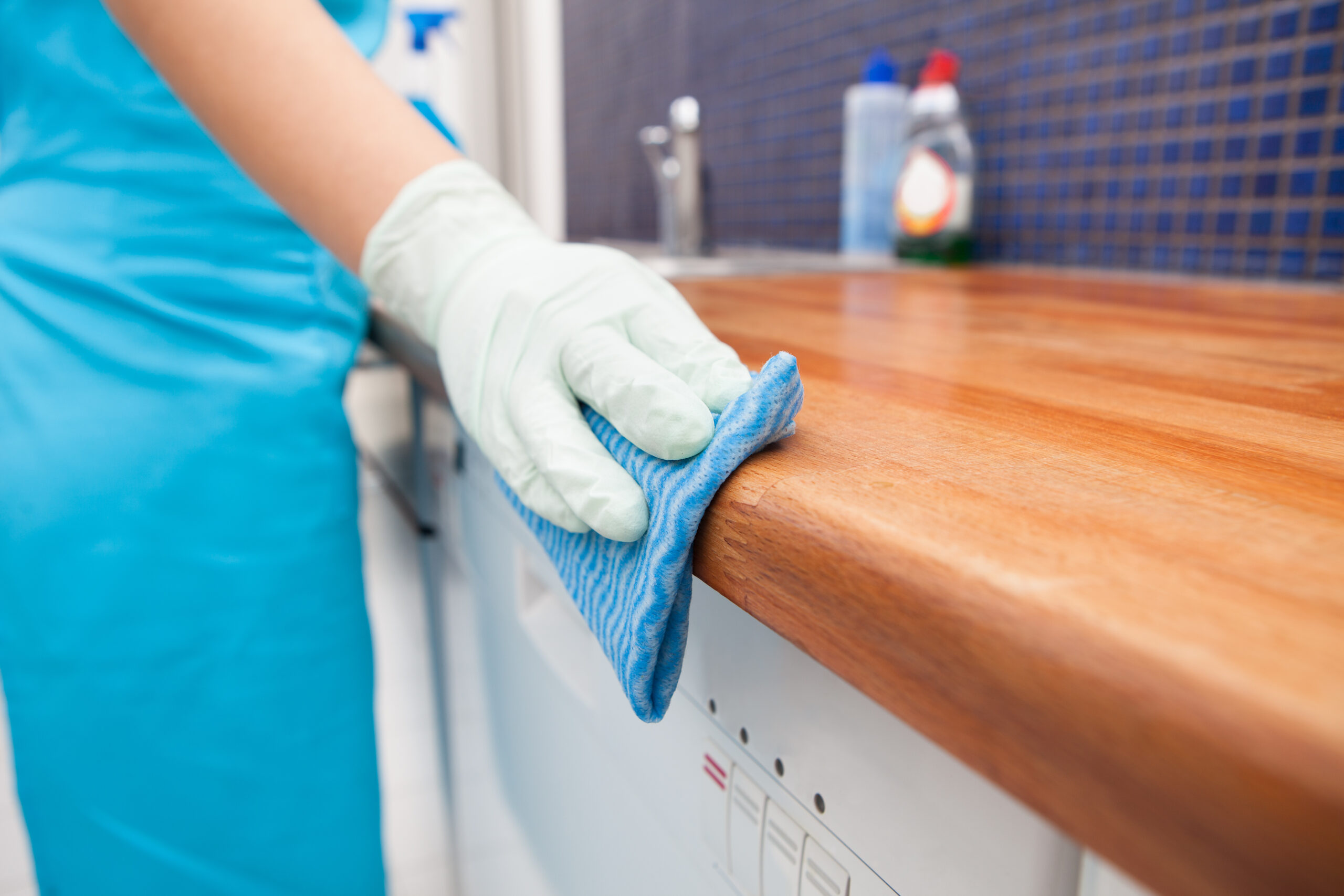 Closeup,Of,Young,Woman,Wearing,Apron,Cleaning,Kitchen,Worktop